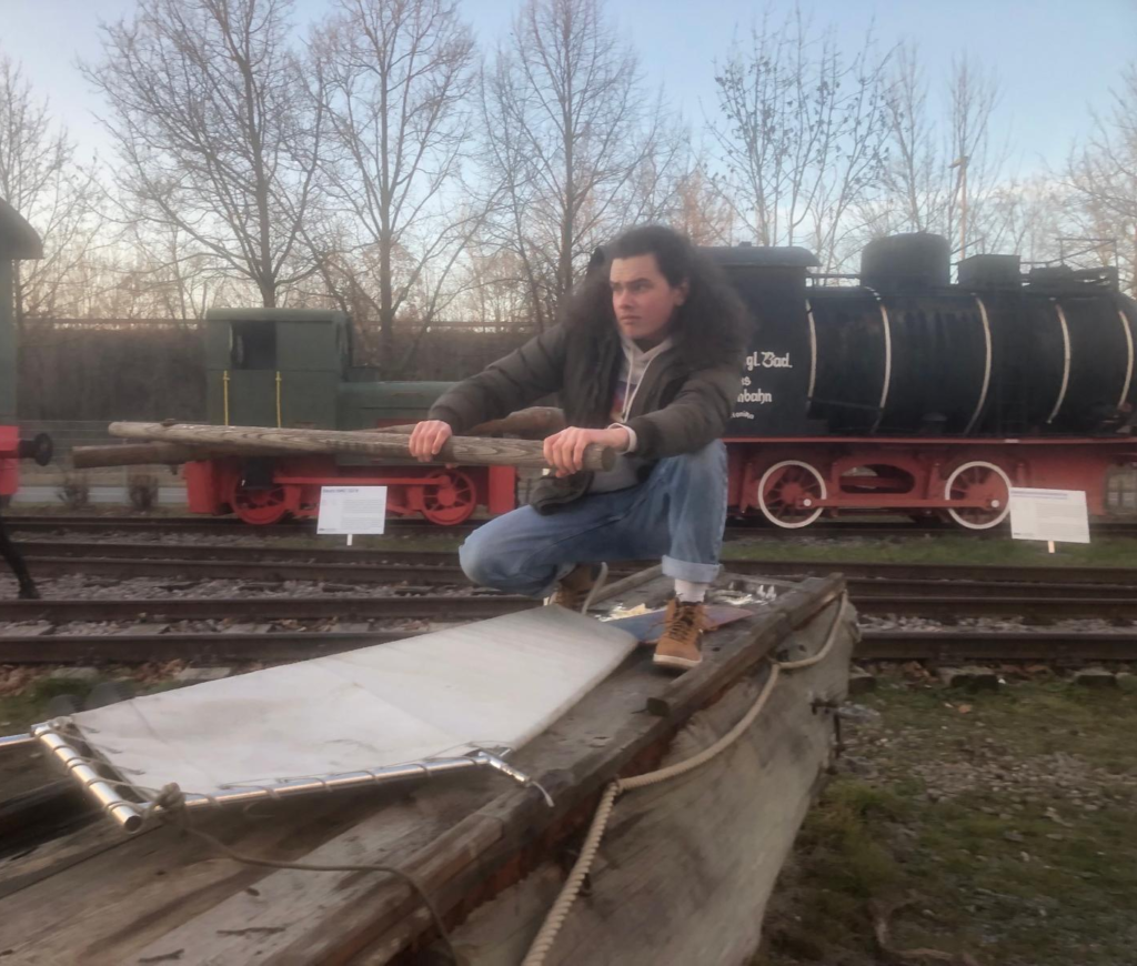 Nicolas steers a log raft into a railyard